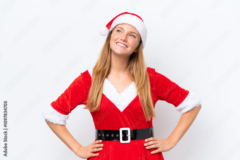 Young caucasian woman dressed as mama noel isolated on white background posing with arms at hip and smiling Young caucasian woman dressed as mama noel isolated on white background posing with arms at hip and smiling