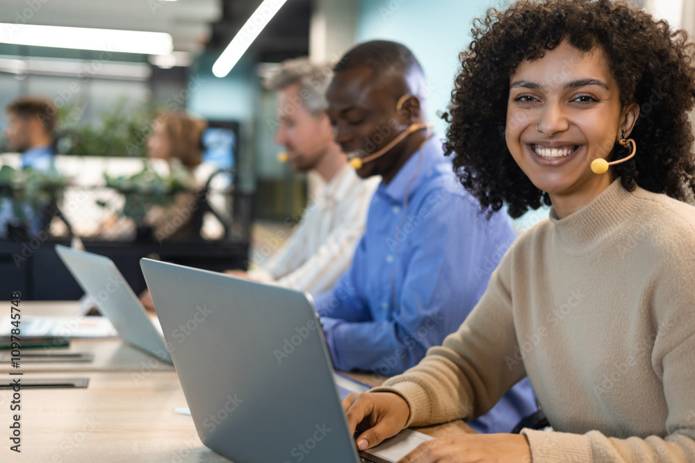Portrait of call center worker accompanied by her team. Smiling customer support operator at work. Portrait of call center worker accompanied by her team. Smiling customer support operator at work.