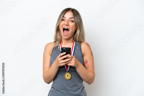 Young Rumanian woman with medals isolated on white background surprised and sending a message photo