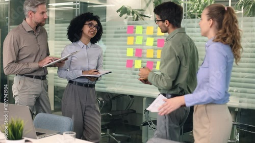 Creative group or business people planning innovation with sticky notes on glass wall.