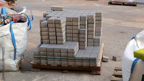 Stack of curbstone blocks and garbage bags near street repair site in urban area photo