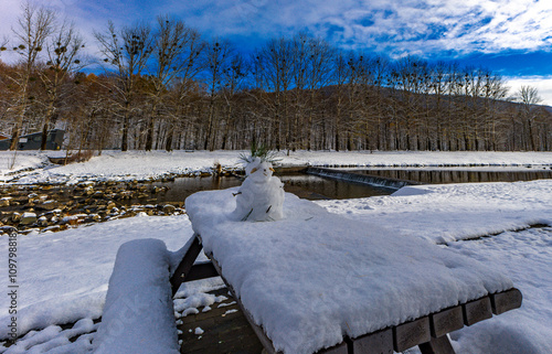 Little snowman made of snow by the river photo