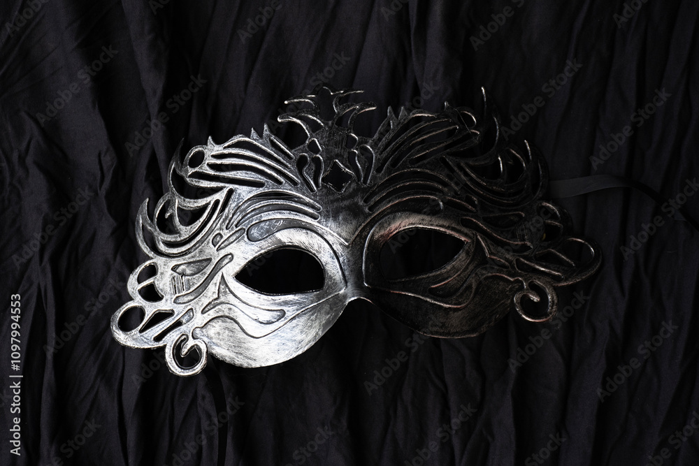 carnival vintage silver mask put on black cloth background.