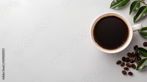 A white coffee cup with a black liquid in it sits on a table with coffee grounds