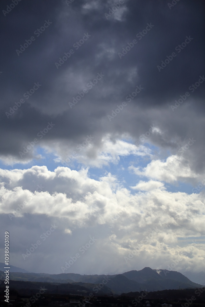 Naklejka premium 雨雲と雲が混じり合った雨上がりの冬の空