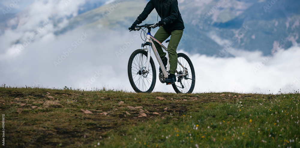 Asian woman riding mountain bike on beautiful mountain top Asian woman riding mountain bike on beautiful mountain top