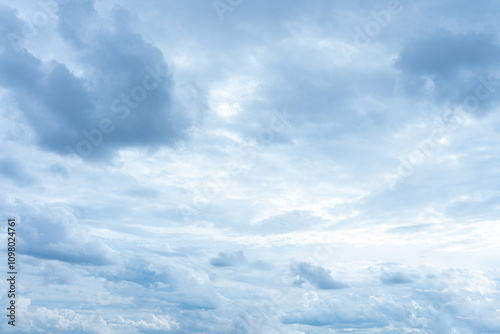 Beautiful fluffy white clouds drift across a bright blue summer sky