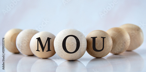 MOU - acronym on wooden balls on a light background photo