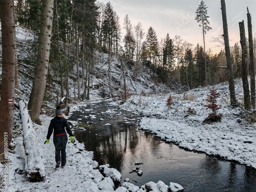 A serene winter view of the Doubravka River valley near Chotebor, featuring calm flowing waters, snow-covered rocks, and the natural beauty of the Czech countryside.