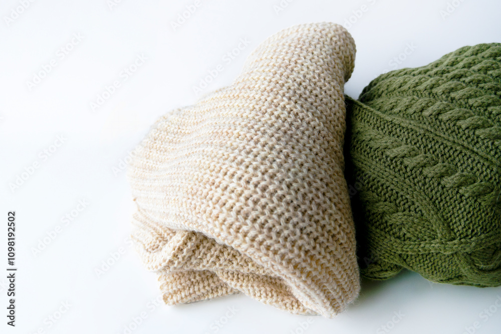 Fototapeta premium closeup of a beige and green cozy sweaters with braids rib clothing warm