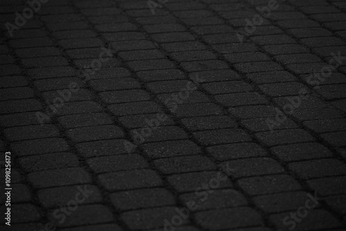 A detailed, high-contrast black and white close-up of a cobblestone texture. Black cobblestone background