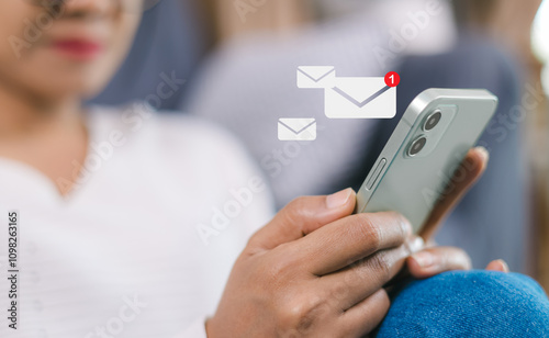 Online communication, online marketing, Data link tech, Woman holding smartphone and touching with virtual icon white newsletter for electronic mail or E-mail with notification alert. photo