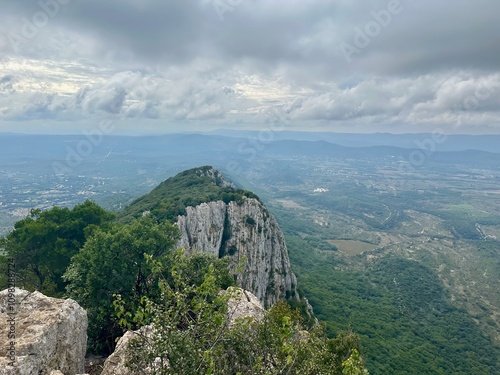 Aerial View of Rugged Limestone Cliffs and Verdant Hills at Pic Saint-Loup, Overlooking the Vast Plains of Southern France Under Moody Skies