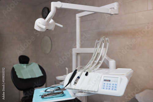 Dental chair in modern dental office equipped with advanced dental instruments and tools. Clean and organized setup ready for next patient, ensuring hygienic and professional environment photo