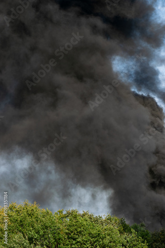 black smoke in forest area near residential buildings in city. vertical frame