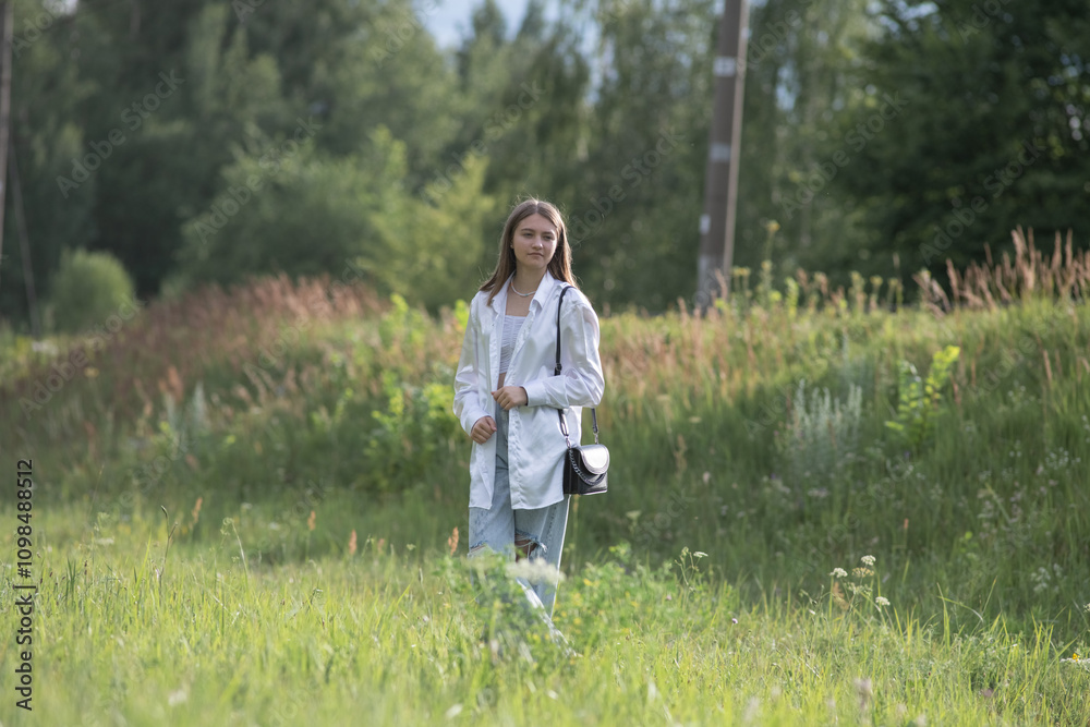 Fototapeta premium Young beautiful girl in a summer park in nature.