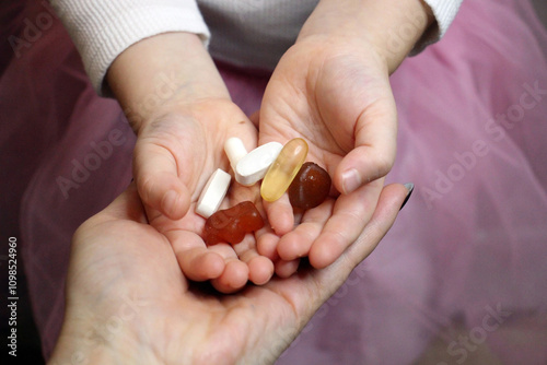 Parent gives pills to toddler. various pills and vitamins on a soft background, representing health, supplements, or medical concepts