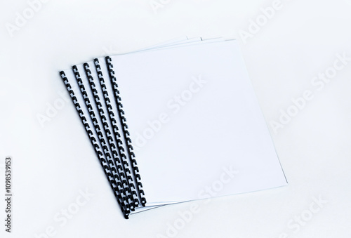 Binded documents with plastic spiral on white background.