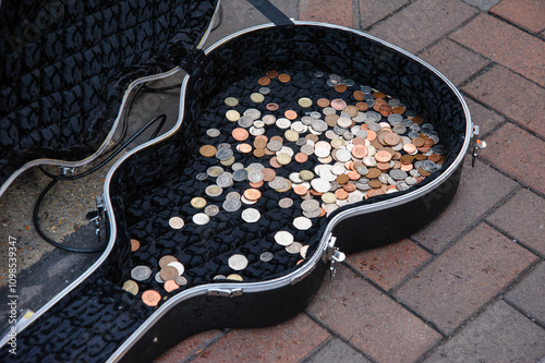Pennies and pound coins inside the guitar case of a street musician busker, UK