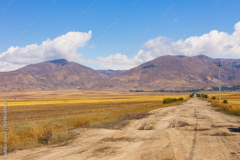 Obraz premium Truck on the gravel road. Lake Sevan area. Mountains in the background. Sevan, Armenia.