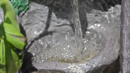 A small water fountain spews forth water on a sunny day in the spring season. 