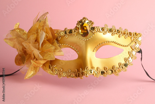 Beautiful golden carnival mask on pink background photo