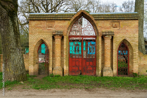 An old brick arch with columns and a wooden door. Historical value. photo