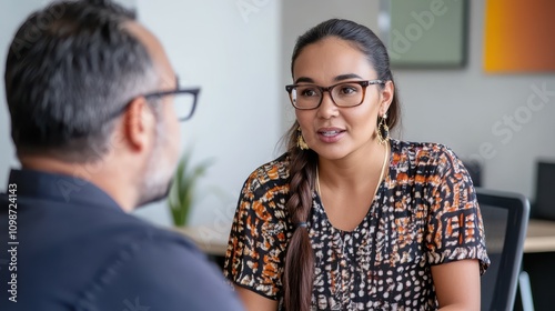 Aboriginal woman talking to a man with glasses in an office
