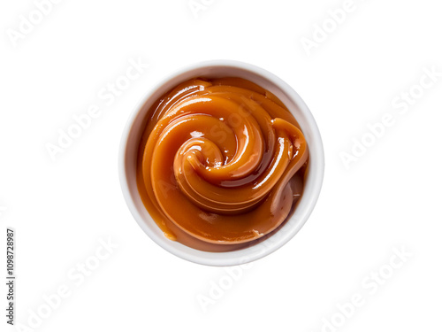 Caramel sauce, in a white bowl. Thick, creamy, sweet dessert, top down view, isolated on a transparent background. photo