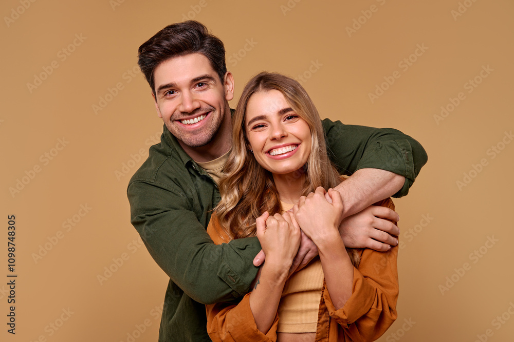 Fototapeta premium A Joyful Young Couple Embracing Each Other Against a Beautifully Warm Background