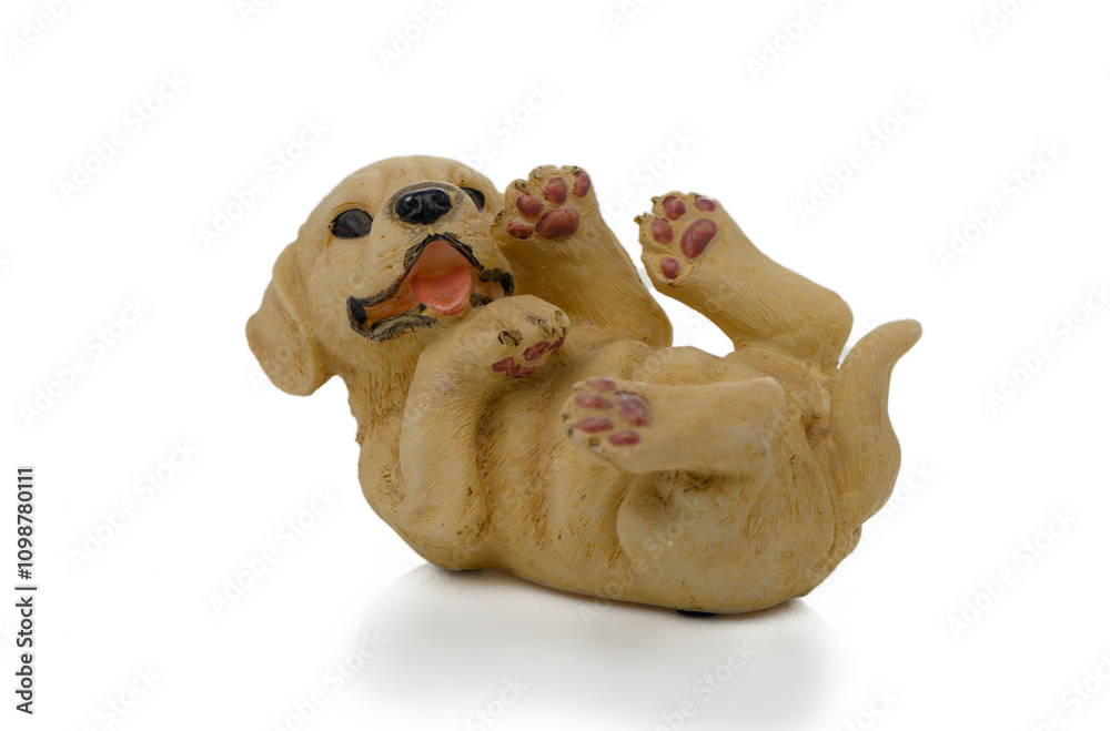 Fototapeta premium Playful ceramic puppy figurine lying on its back with a joyful expression and raised paws