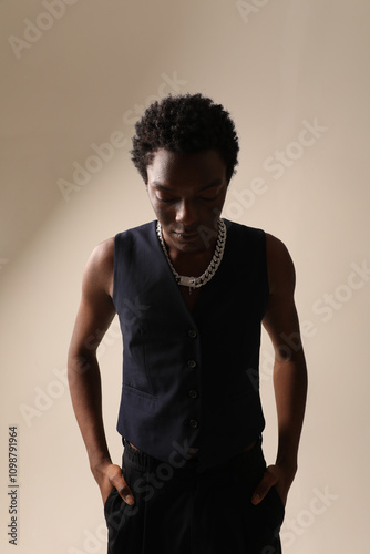 Indoor portrait of young African American man posing over light background. Vertical mock-up.