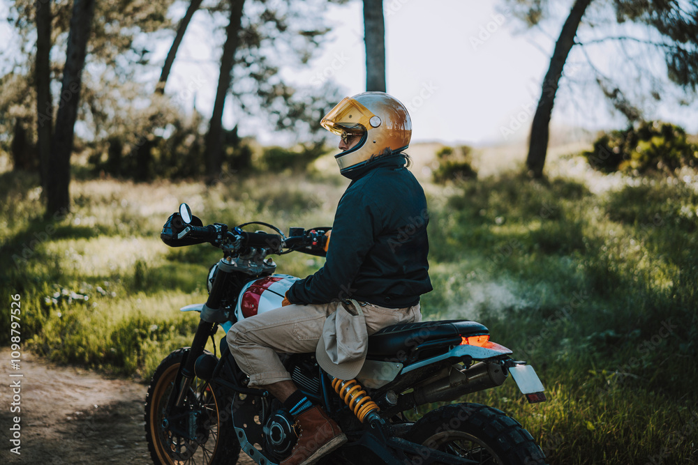 Hombre con barba y estilo alternativo con moto de campo en paso de bosque