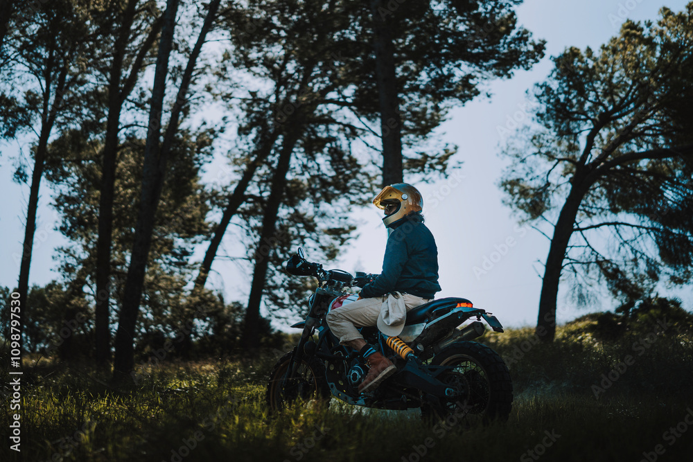 Hombre con barba y estilo alternativo con moto de campo en paso de bosque