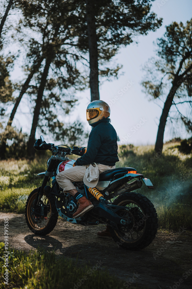 Fototapeta premium Hombre con barba y estilo alternativo con moto de campo en paso de bosque