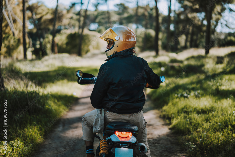 Hombre con barba y estilo alternativo con moto de campo en paso de bosque