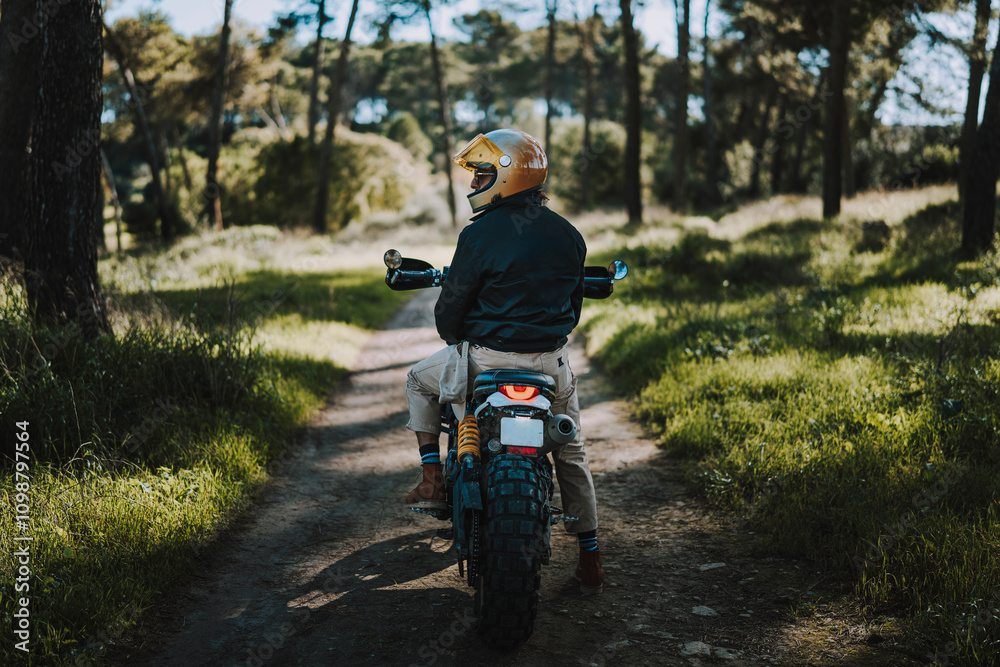 Hombre con barba y estilo alternativo con moto de campo en paso de bosque