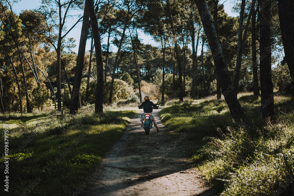 Hombre con barba y estilo alternativo con moto de campo en paso de bosque