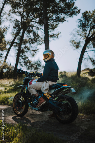 Hombre con barba y estilo alternativo con moto de campo en paso de bosque 