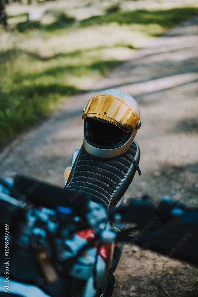 Primer plano de motocicleta de campo en bosque con casco en el sillón en camino de tierra