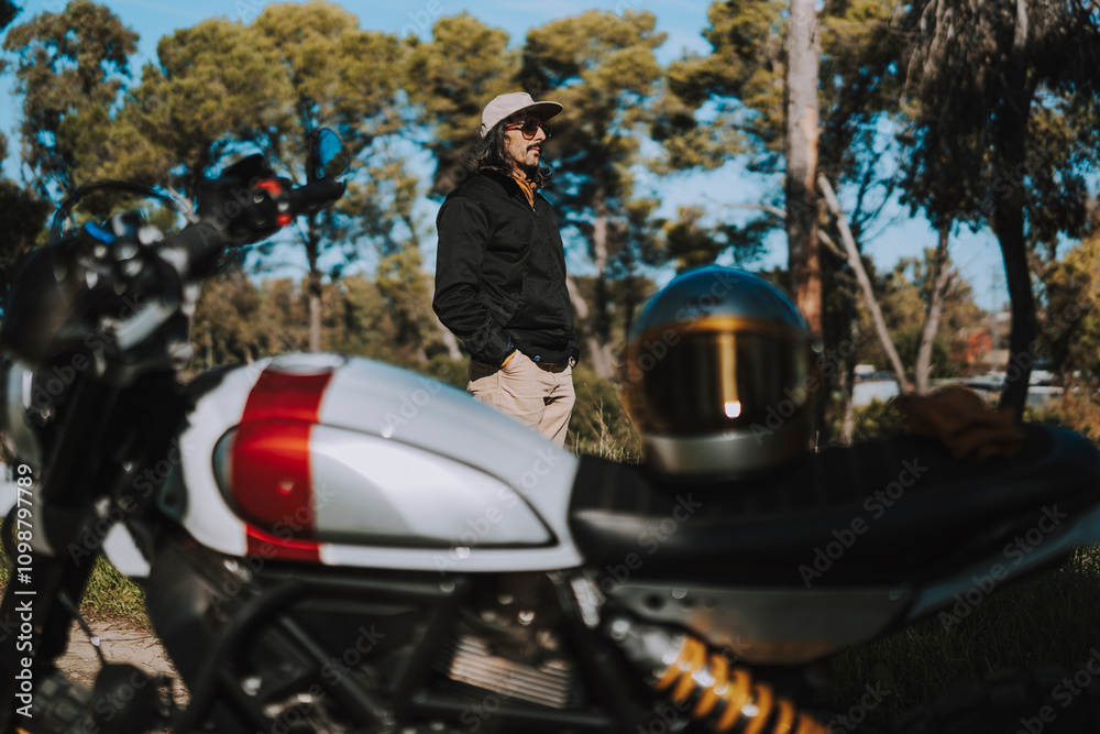 Hombre con barba y estilo alternativo con moto de campo en paso de bosque