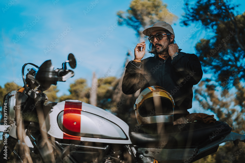 Hombre con barba y estilo alternativo con moto de campo en paso de bosque