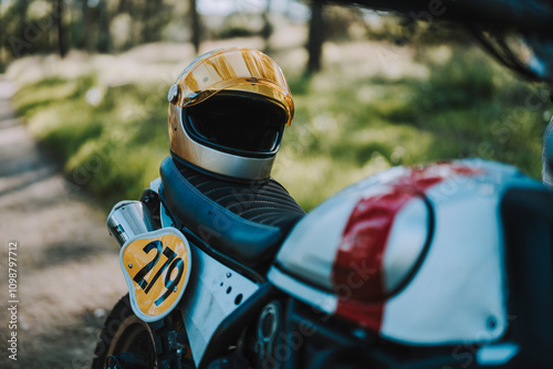 Primer plano de motocicleta de campo en bosque con casco en el sillón en camino de tierra