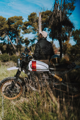 Obraz na płótnie Hombre con barba y estilo alternativo con moto de campo en paso de bosque w salonie