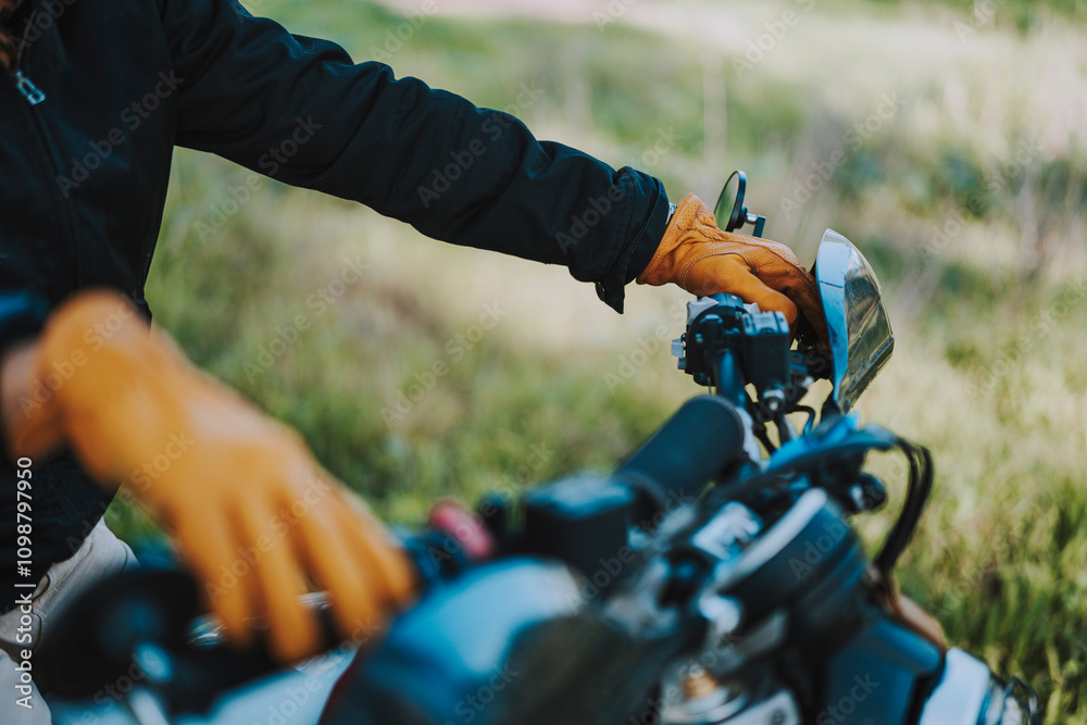 Foto detalle de mano con guante amarillo de cuero en manillar de moto de campo