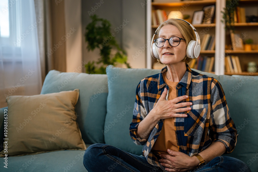 Obraz premium Mature senior woman practice guided meditation manifestation at home