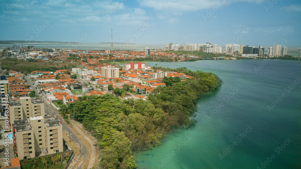 Fototapeta premium Panoramic drone view of Lagoa da Jansen, a lagoon in Sao Luis, Maranhao, Brazil. Beautiful urban landscape with nature, water, and the city skyline in harmony.