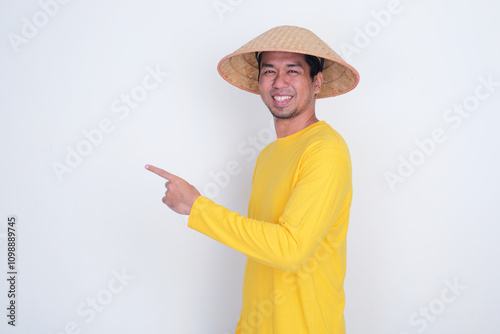 A farmer smiling confidence with one hand pointing beside him photo