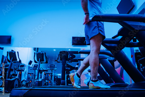 Deportista entrenando en gimnasio sobre cinta de correr.