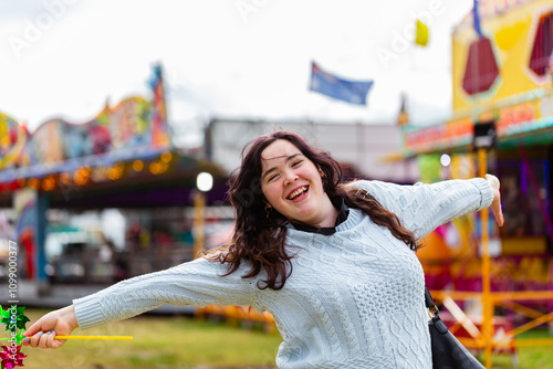 Smiling young woman at country show event smiling and holding a pinwheel on windy day photo